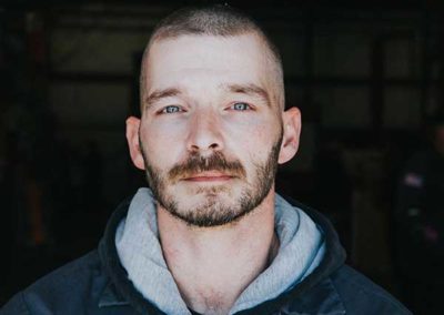 Chad King - Short dark hair with brown eyebrows, blue eyes and dark short mustache and beard.