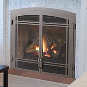 Brown arched metal fireplace insert with wood burning in it and black coffee table in front of it