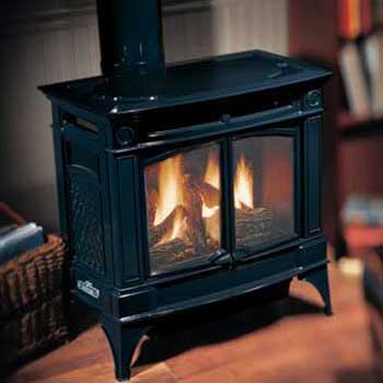 Stock Photo-Hampton H 35 large Gas Stove-Ashbusters Chimney - Nashville TN Large black Gas Stove in home with fire burning and wicker basket on floor next to it